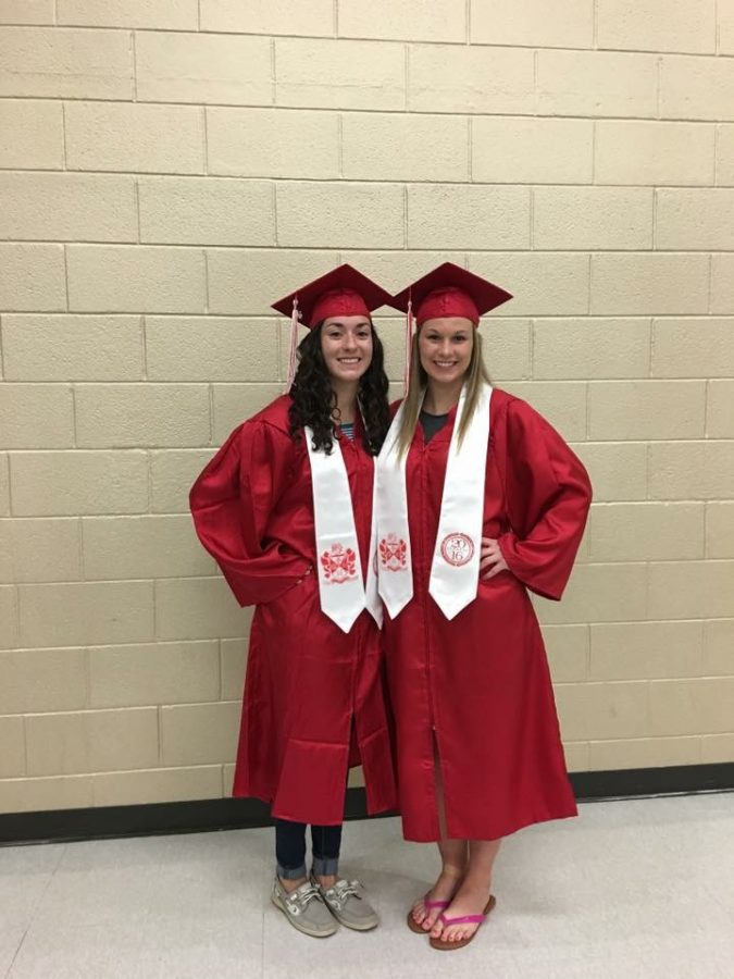 Seniors Lindsey Moore and Amanda Linden pose for photos in their caps and gowns.