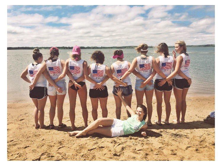 Senior girls pose outside the lake with their senior skip day shirts. 