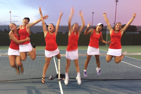 The MHS girls varsity jumps with joy after receiving their first place medals at the Hesston Invitational. 