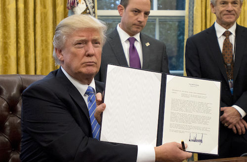 WASHINGTON, DC - JANUARY 23:  (AFP OUT) U.S. President Donald Trump shows the Executive Order withdrawing the US from the Trans-Pacific Partnership (TPP) after signing it in the Oval Office of the White House in Washington, DC on Monday, January 23, 2017.  The other two Executive Orders concerned a US Government hiring freeze for all departments but the military, and "Mexico City" which bans federal funding of abortions overseas. (Photo by Ron Sachs - Pool/Getty Images)