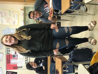 Kendall Boughfman is wearing ripped jeans with a grey sweater and white Birkenstock 