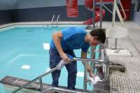 Students participate by helping clean the pool at the YMCA. 