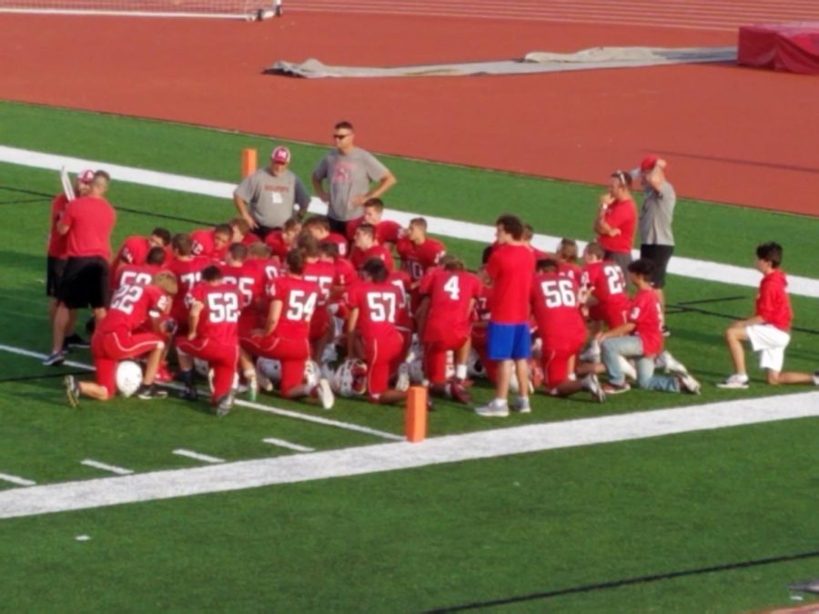 Freshman team huddle up during halftime to discuss strategies for second half of the game.