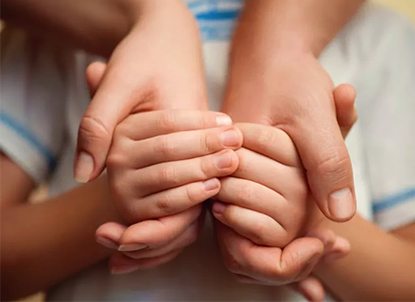 adopted kids holding adoptive parents hands